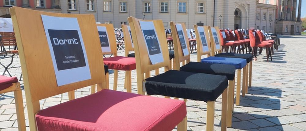 Mit 150 leeren Stühlen haben Potsdamer Gastronomen auf dem Alten Markt gegen die andauernde Schließung ihrer Häuser protestiert.