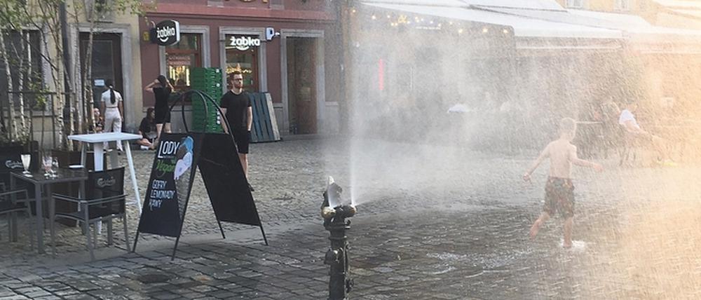 Der Sprühnebelbrunnen auf dem Rynek, dem großen Marktplatz von Breslau, sorgt an heißen Tagen für Erfrischung bei Jung und Alt.
