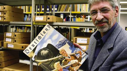 Der Leiter des Archivs für Tourismus, Hasso Spode, zeigt eine historische Ausgabe der Zeitschrift Deutschland.