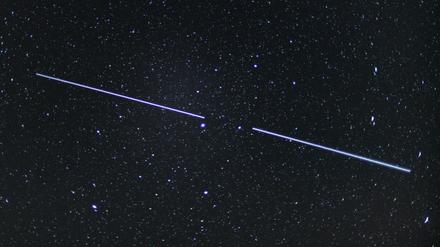 Zwei "Starlink"-Satelliten sind als Lichtstreifen am Nachthimmel zu sehen.