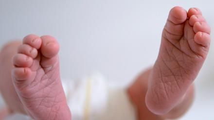 Ein neugeborenes Baby strampelt mit den Füßen.