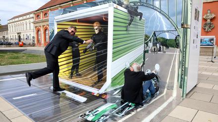 Bürgermeister Burkhard Exner (SPD, links) demonstriert ein 3D-TrickArt-Bild vor dem Filmmuseum.