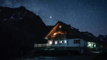 Die Potsdamer Hütte bei Nacht unter einem klaren Sternenhimmel.