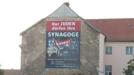 Protestplakat am Nachbarhaus des Synagogenbaufelds in der Potsdamer Mitte.
