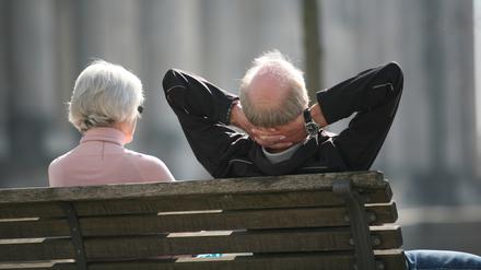 Ein Rentnerpaar sitzt auf einer Bank und sonnt sich (Symbolbild).
