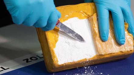 Ein Zollbeamter öffnet ein Paket mit Kokain, das von Beamten sichergestellt wurde. In Potsdam ist ein Kurier bei der Drogenübergabe geschlagen worden. (Symbolbild)