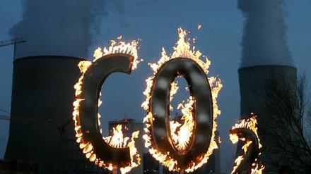 Mit einem brennenden CO 2-Zeichen demonstrierten Mitglieder der Umweltschutzorganisation Greenpeace vor dem Kohlekraftwerk Staudinger gegen den Schadstoffausstoß des Kraftwerkes.