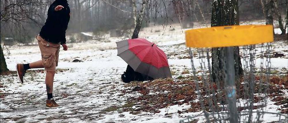 Mit Frisbee und Regenschirm. Torsten Baus, Deutscher Vize-Meister von 2012, schützt seine Flugscheiben vor der direkten Nässe.