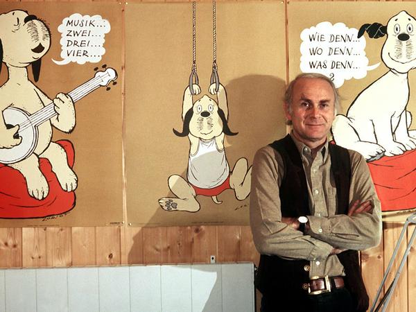 Vicco von Bülow alias Loriot steht in seinem Haus vor Plakaten mit dem Zeichentrickhund "Wum". Das Foto stammt aus dem Jahr 1973.