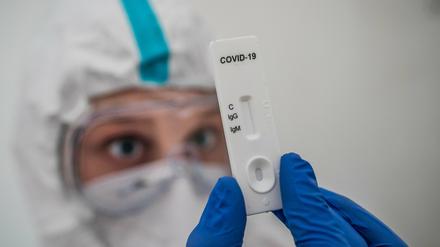 Ein Mediziner prüft einen Schnelltest zum Covid-19-Antikörper-Nachweis.
