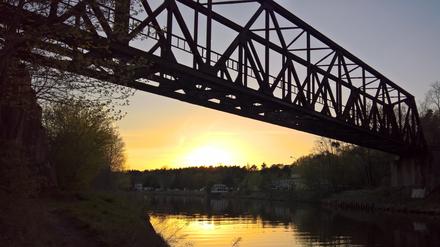 Die alte Brücke der Friedhofsbahn am Teltow-Kanal in der Abendsonne.