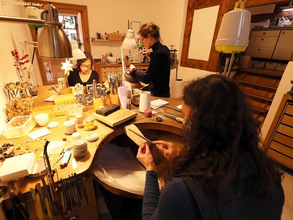 Die drei Schmuckdesignerinnen bei der Arbeit in ihrer Werkstatt.  