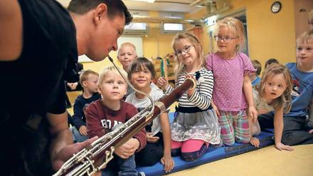 Vitaly Shlyakhov geht mit seinem Fagott dicht an die Kinder heran, damit sie die Schwingungen des Instrumentes spüren können. 