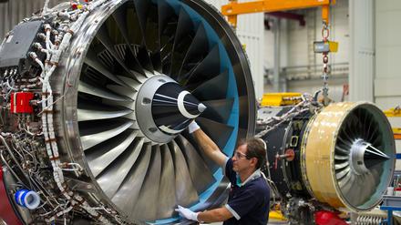 Ein Mechaniker des britischen Triebwerksherstellers Rolls-Royce arbeitet an einem Flugzeugtriebwerk im Werk in Dahlewitz. 