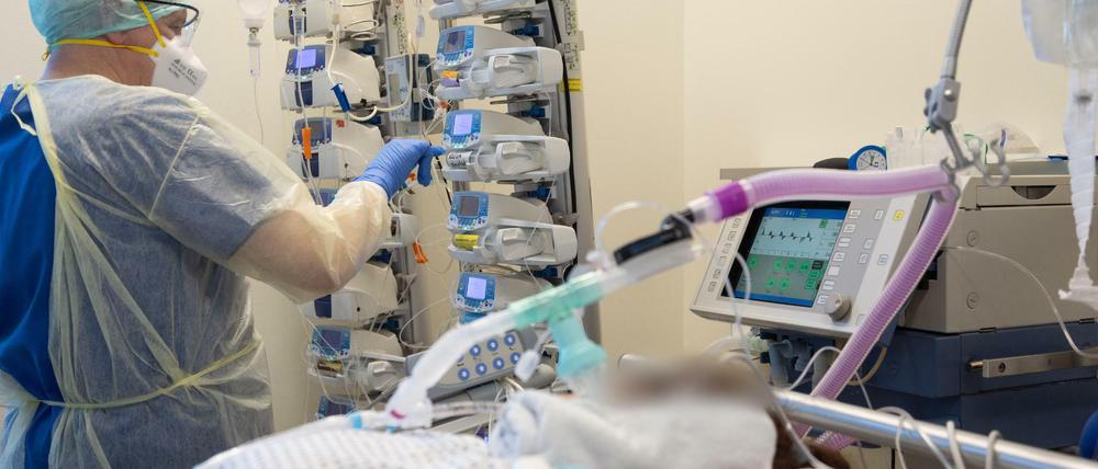 Ein Krankenpfleger versorgt einen schwer an Corona erkrankten Patienten auf der Intensivstation von einem Krankenhaus.