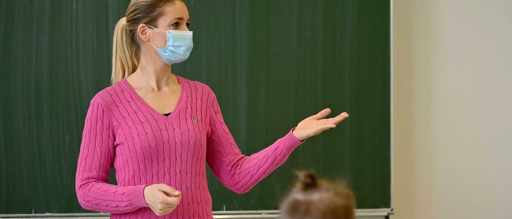 Lehrerin mit Mundschutzmaske im Präsenzunterricht in Stuttgart, Baden-Württemberg.